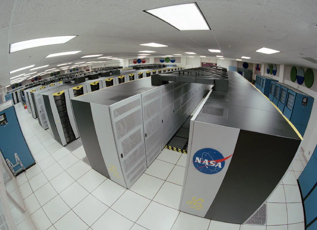Rows of server racks in a high-performance computing facility, lit by status lights.
